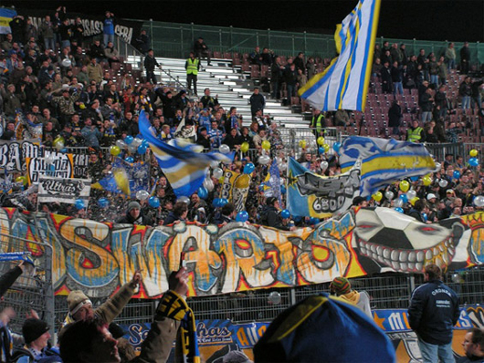 Jena-Fans beim Auswärtsspiel gegen St. Pauli.<br />Bild: Horda Azzuro“><figcaption>Jena-Fans beim Auswärtsspiel gegen St. Pauli.<br />Bild: Horda Azzuro</figcaption></figure>
            </div>

                    </article>

                <section class=