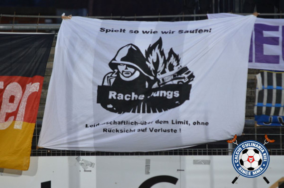 Die Zaunfahne der Rache Jungs Neumünster<br />Bild: Calcio-Culinaria.de”><figcaption>Die Zaunfahne der Rache Jungs Neumünster<br />Bild: Calcio-Culinaria.de</figcaption></figure>
                </div>
                
                <!-- YouTube (Meta-Feld) -->
                
            </div>
        </article>

                <script>
        (function() {
            var root = document.querySelector('.ff-single-news-gallery');
            if (!root) return;
            var slides = root.querySelectorAll('.ff-single-news-gallery-slide');
            var dots = root.querySelectorAll('.ff-single-news-gallery-dot');
            var prev = root.querySelector('.ff-single-news-gallery-prev');
            var next = root.querySelector('.ff-single-news-gallery-next');
            var n = slides.length;
            if (n < 2) return;
            var i = 0;
            function closeAllImgInfo() {
                root.querySelectorAll('.ff-fv-img-info-host.is-info-open').forEach(function(host) {
                    host.classList.remove('is-info-open');
                    var b = host.querySelector('.ff-fv-img-info-btn');
                    var p = host.querySelector('.ff-fv-img-info-panel');
                    if (b) b.setAttribute('aria-expanded', 'false');
                    if (p) p.setAttribute('aria-hidden', 'true');
                });
            }
            function show(idx) {
                closeAllImgInfo();
                i = ((idx % n) + n) % n;
                for (var s = 0; s < n; s++) {
                    if (s === i) slides[s].removeAttribute('hidden'); else slides[s].setAttribute('hidden', '');
                }
                for (var s = 0; s < dots.length; s++) {
                    dots[s].classList.toggle('is-active', s === i);
                    dots[s].setAttribute('aria-selected', s === i ? 'true' : 'false');
                }
            }
            if (prev) prev.addEventListener('click', function() { show(i - 1); });
            if (next) next.addEventListener('click', function() { show(i + 1); });
            for (var d = 0; d < dots.length; d++) {
                (function(di) { dots[di].addEventListener('click', function() { show(di); }); })(d);
            }
        })();
        </script>
        
        <!-- Kommentare -->
                <section class=