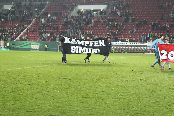 Nach Abpfiff zeigten FCA-Spieler das Kämpfen Simon Plakat der Legio Augusta<br />    <button type=