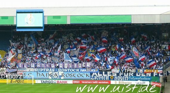 Die Rostocker Südtribüne beim Pokalspiel<br />Bild: Unterwegs in Sachen Fussball – www.uisf.de”><figcaption>Die Rostocker Südtribüne beim Pokalspiel<br />Bild: Unterwegs in Sachen Fussball – www.uisf.de</figcaption></figure>
<figure><img decoding=
