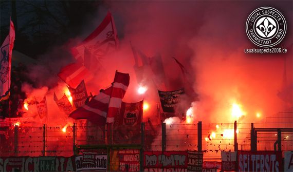 Pyroshow der FC Bayern Fans in Darmstadt.<br />Bild: usualsuspects2006.de”><figcaption>Pyroshow der FC Bayern Fans in Darmstadt.<br />Bild: usualsuspects2006.de</figcaption></figure>
<figure><img decoding=