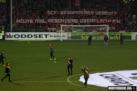 Spruchband mit Kritik an der Halbzeitshow.<br />Bild: Nordtribuene.org”><figcaption>Spruchband mit Kritik an der Halbzeitshow.<br />Bild: Nordtribuene.org</figcaption></figure>
<figure><img decoding=