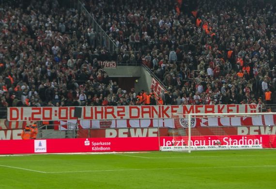 Die Wilde Horde machte scherzhaft die anwesende Bundeskanzlerin für die Anstoßzeit verantwortlich.<br />Bild: Eintracht-Online.net”><figcaption>Die Wilde Horde machte scherzhaft die anwesende Bundeskanzlerin für die Anstoßzeit verantwortlich.<br />Bild: Eintracht-Online.net</figcaption></figure>
<figure><img decoding=