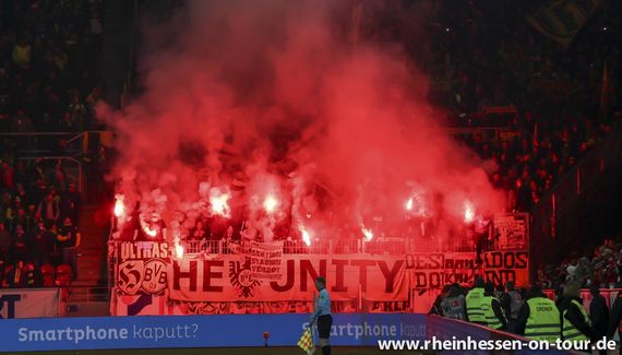 Auch diese Pyroshow der BVB-Ultras in Mainz wurde vom DFB sanktioniert.<br />Bild: Rheinhessen-on-tour.de”><figcaption>Auch diese Pyroshow der BVB-Ultras in Mainz wurde vom DFB sanktioniert.<br />Bild: Rheinhessen-on-tour.de</figcaption></figure>
<figure><img decoding=