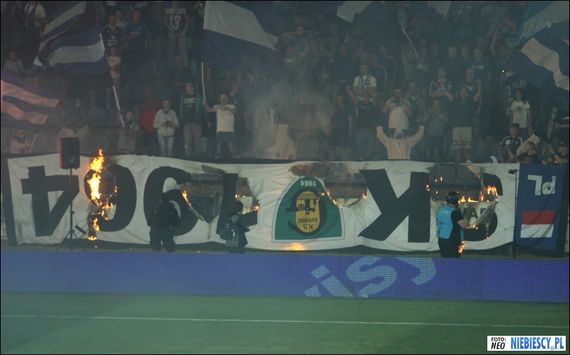 Ruch-Fans verbrannten beim letzten Heimspiel schon zwei Zaunfahnen von GKS Katowice<br />Bild: niebiescy.pl“><figcaption>Ruch-Fans verbrannten beim letzten Heimspiel schon zwei Zaunfahnen von GKS Katowice<br />Bild: niebiescy.pl</figcaption></figure>
<figure><img decoding=