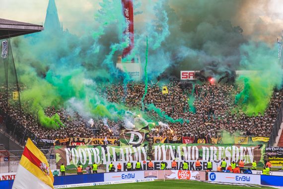 Pyroaktion der Dynamo-Fans in Karlsruhe.<br />Bild: Supporters-Karlsruhe.de”><figcaption>Pyroaktion der Dynamo-Fans in Karlsruhe.<br />Bild: Supporters-Karlsruhe.de</figcaption></figure>
<figure><img decoding=