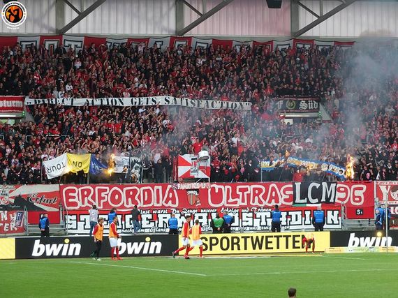 Geklaute FCC-Zaunfahnen in der Steigerwaldkurve.<br />Bild: Unterwegs in Sachen Fussball – www.uisf.de”><figcaption>Geklaute FCC-Zaunfahnen in der Steigerwaldkurve.<br />Bild: Unterwegs in Sachen Fussball – www.uisf.de</figcaption></figure>
<figure><img decoding=