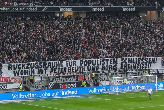 Das Spruchband gegen die hessischen Minister.<br />Bild: Eintracht-Online.net”><figcaption>Das Spruchband gegen die hessischen Minister.<br />Bild: Eintracht-Online.net</figcaption></figure>
<figure><img decoding=
