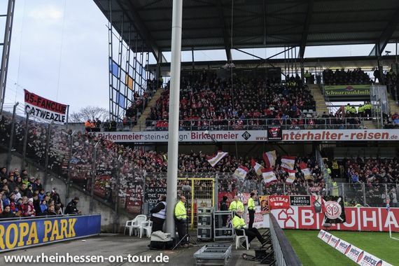 Die Fahne rechts im Bild soll von einem Ordner abgerissen worden sein.<br />Bild: rheinhessen-on-tour.de”><figcaption>Die Fahne rechts im Bild soll von einem Ordner abgerissen worden sein.<br />Bild: rheinhessen-on-tour.de</figcaption></figure>
<figure><img decoding=