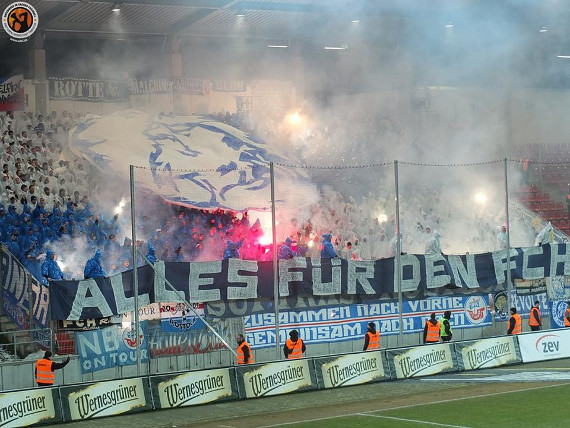 Mit Pyro untermalte Choreografie von Hansa-Fans in Zwickau.<br />Bild: Unterwegs in Sachen Fussball – www.uisf.de”><figcaption>Mit Pyro untermalte Choreografie von Hansa-Fans in Zwickau.<br />Bild: Unterwegs in Sachen Fussball – www.uisf.de</figcaption></figure>
<figure><img decoding=