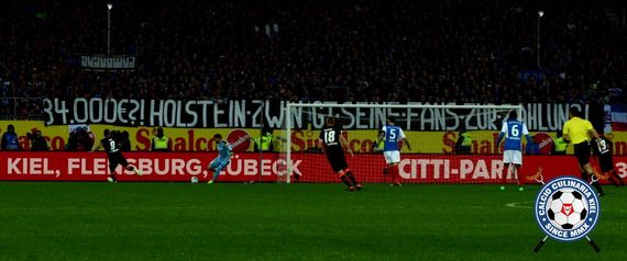 Spruchband der Holstein Kiel-Fanszene zum Thema.<br />Bild: Calcio-Culinaria.de”><figcaption>Spruchband der Holstein Kiel-Fanszene zum Thema.<br />Bild: Calcio-Culinaria.de</figcaption></figure>
<figure><img decoding=