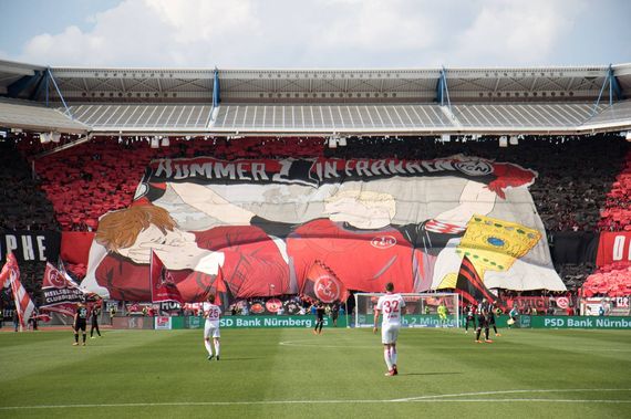 Die Blockfahne in der Nordkurve Nürnberg.<br />Bild: Supporters Club 1. FC Nürnberg”><figcaption>Die Blockfahne in der Nordkurve Nürnberg.<br />Bild: Supporters Club 1. FC Nürnberg</figcaption></figure>
<figure><img decoding=