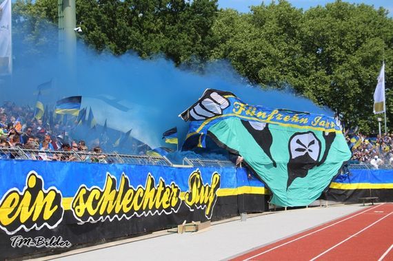 Die Choreografie und Pyroshow in Block 1.<br />Bild: Forzsa-TuS.de”><figcaption>Die Choreografie und Pyroshow in Block 1.<br />Bild: Forzsa-TuS.de</figcaption></figure>
<figure><img decoding=