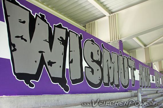 Die Erzbrigade hat auch die Hinterwand der Westtribüne verschönert.<br />Bild: Veilchenpower.de”><figcaption>Die Erzbrigade hat auch die Hinterwand der Westtribüne verschönert.<br />Bild: Veilchenpower.de</figcaption></figure>
<figure><img decoding=