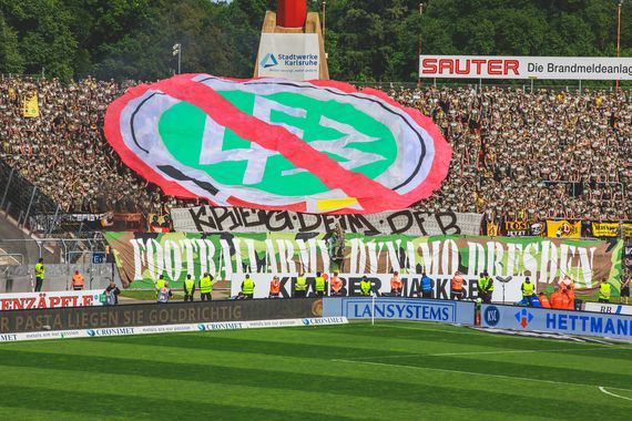 Die Camouflage-Mottotour der Dynamo-Fans nach Karlsruhe.<br />Bild: Supporters-Karlsruhe.de”><figcaption>Die Camouflage-Mottotour der Dynamo-Fans nach Karlsruhe.<br />Bild: Supporters-Karlsruhe.de</figcaption></figure>
                </div>
                
                <!-- YouTube (Meta-Feld) -->
                
            </div>
        </article>

                <script>
        (function() {
            var root = document.querySelector('.ff-single-news-gallery');
            if (!root) return;
            var slides = root.querySelectorAll('.ff-single-news-gallery-slide');
            var dots = root.querySelectorAll('.ff-single-news-gallery-dot');
            var prev = root.querySelector('.ff-single-news-gallery-prev');
            var next = root.querySelector('.ff-single-news-gallery-next');
            var n = slides.length;
            if (n < 2) return;
            var i = 0;
            function closeAllImgInfo() {
                root.querySelectorAll('.ff-fv-img-info-host.is-info-open').forEach(function(host) {
                    host.classList.remove('is-info-open');
                    var b = host.querySelector('.ff-fv-img-info-btn');
                    var p = host.querySelector('.ff-fv-img-info-panel');
                    if (b) b.setAttribute('aria-expanded', 'false');
                    if (p) p.setAttribute('aria-hidden', 'true');
                });
            }
            function show(idx) {
                closeAllImgInfo();
                i = ((idx % n) + n) % n;
                for (var s = 0; s < n; s++) {
                    if (s === i) slides[s].removeAttribute('hidden'); else slides[s].setAttribute('hidden', '');
                }
                for (var s = 0; s < dots.length; s++) {
                    dots[s].classList.toggle('is-active', s === i);
                    dots[s].setAttribute('aria-selected', s === i ? 'true' : 'false');
                }
            }
            if (prev) prev.addEventListener('click', function() { show(i - 1); });
            if (next) next.addEventListener('click', function() { show(i + 1); });
            for (var d = 0; d < dots.length; d++) {
                (function(di) { dots[di].addEventListener('click', function() { show(di); }); })(d);
            }
        })();
        </script>
        
        <!-- Kommentare -->
                <section class=