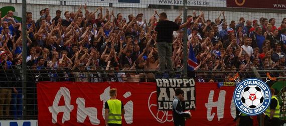 Auch die Holstein Kiel-Fanszene macht für das Derby am Samstag mobil.<br />Bild: Calcio-Culinaria.de”><figcaption>Auch die Holstein Kiel-Fanszene macht für das Derby am Samstag mobil.<br />Bild: Calcio-Culinaria.de</figcaption></figure>
                </div>
                
                <!-- YouTube (Meta-Feld) -->
                
            </div>
        </article>

                <script>
        (function() {
            var root = document.querySelector('.ff-single-news-gallery');
            if (!root) return;
            var slides = root.querySelectorAll('.ff-single-news-gallery-slide');
            var dots = root.querySelectorAll('.ff-single-news-gallery-dot');
            var prev = root.querySelector('.ff-single-news-gallery-prev');
            var next = root.querySelector('.ff-single-news-gallery-next');
            var n = slides.length;
            if (n < 2) return;
            var i = 0;
            function closeAllImgInfo() {
                root.querySelectorAll('.ff-fv-img-info-host.is-info-open').forEach(function(host) {
                    host.classList.remove('is-info-open');
                    var b = host.querySelector('.ff-fv-img-info-btn');
                    var p = host.querySelector('.ff-fv-img-info-panel');
                    if (b) b.setAttribute('aria-expanded', 'false');
                    if (p) p.setAttribute('aria-hidden', 'true');
                });
            }
            function show(idx) {
                closeAllImgInfo();
                i = ((idx % n) + n) % n;
                for (var s = 0; s < n; s++) {
                    if (s === i) slides[s].removeAttribute('hidden'); else slides[s].setAttribute('hidden', '');
                }
                for (var s = 0; s < dots.length; s++) {
                    dots[s].classList.toggle('is-active', s === i);
                    dots[s].setAttribute('aria-selected', s === i ? 'true' : 'false');
                }
            }
            if (prev) prev.addEventListener('click', function() { show(i - 1); });
            if (next) next.addEventListener('click', function() { show(i + 1); });
            for (var d = 0; d < dots.length; d++) {
                (function(di) { dots[di].addEventListener('click', function() { show(di); }); })(d);
            }
        })();
        </script>
        
        <!-- Kommentare -->
                <section class=