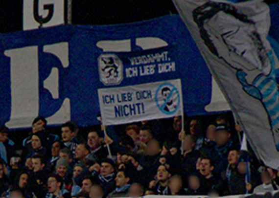 So sah der zensierte Doppelhalter im Original aus.<br />Bild: muenchnerloewen.de”><figcaption>So sah der zensierte Doppelhalter im Original aus.<br />Bild: muenchnerloewen.de</figcaption></figure>
<figure><img decoding=