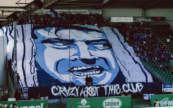 Blockfahne der Lilienfans.<br />Bild: spvgg-fuerth.com”><figcaption>Blockfahne der Lilienfans.<br />Bild: spvgg-fuerth.com</figcaption></figure>
<figure><img decoding=