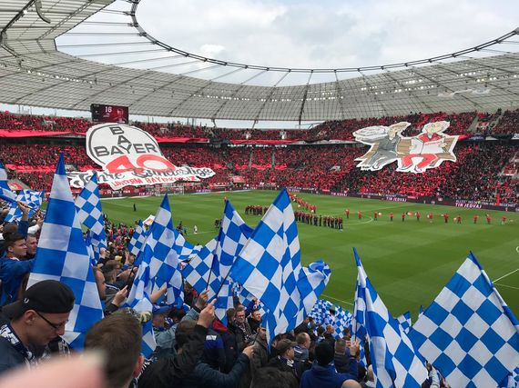 Blick aus dem Gästeblock auf die Choreografie der Bayer-Fans.<br />Bild: Susanneblondundblau”><figcaption>Blick aus dem Gästeblock auf die Choreografie der Bayer-Fans.<br />Bild: Susanneblondundblau</figcaption></figure>
<figure><img decoding=