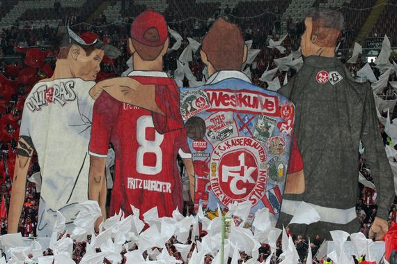 Bei der Choreografie waren ein Ultrà, ein Trikotträger, eine Kutte und ein Hooligan zu sehen.<br />Bild: www.der-betze-brennt.de”><figcaption>Bei der Choreografie waren ein Ultrà, ein Trikotträger, eine Kutte und ein Hooligan zu sehen.<br />Bild: www.der-betze-brennt.de</figcaption></figure>
<figure><img decoding=