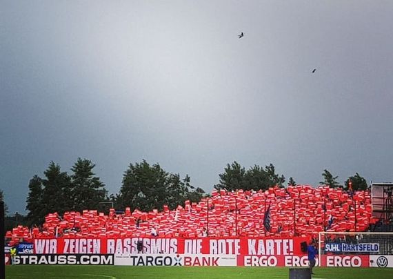 Die mitgereisten Schalke 04-Fans zeigten Rassismus symbolisch die rote Karte.<br />Bild: Schalker Fanprojekt”><figcaption>Die mitgereisten Schalke 04-Fans zeigten Rassismus symbolisch die rote Karte.<br />Bild: Schalker Fanprojekt</figcaption></figure>
<figure><img decoding=