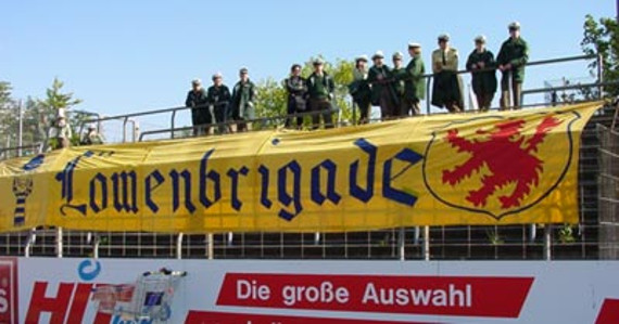 Die Zaunfahne der Löwenbrigade in der Saison 2000/2001 im Kölner Südstadion.<br />Bild: Faszination Fankurve”><figcaption>Die Zaunfahne der Löwenbrigade in der Saison 2000/2001 im Kölner Südstadion.<br />Bild: Faszination Fankurve</figcaption></figure>
<figure><img decoding=