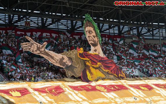 Kaiser Augustus, nachdem die Stadt Augsburg benannt ist, bei der Choreografie auf der Ulrich-Biesinger-Tribüne.<br />Bild: original1907.de”><figcaption>Kaiser Augustus, nachdem die Stadt Augsburg benannt ist, bei der Choreografie auf der Ulrich-Biesinger-Tribüne.<br />Bild: original1907.de</figcaption></figure>
<figure><img decoding=