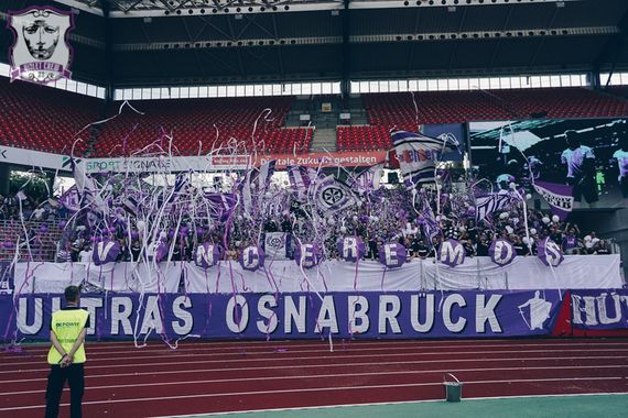Die Gästefans hatten auch die große Ultras Osnabrück-Zaunfahne mit im Gepäck.<br />Bild: violetcrew.de”><figcaption>Die Gästefans hatten auch die große Ultras Osnabrück-Zaunfahne mit im Gepäck.<br />Bild: violetcrew.de</figcaption></figure>
<figure><img decoding=