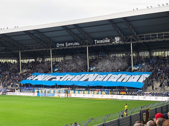 Die Blockfahne auf der Otto-Siffling-Tribüne.<br />Bild: Sportplatzmensch”><figcaption>Die Blockfahne auf der Otto-Siffling-Tribüne.<br />Bild: Sportplatzmensch</figcaption></figure>
<figure><img decoding=