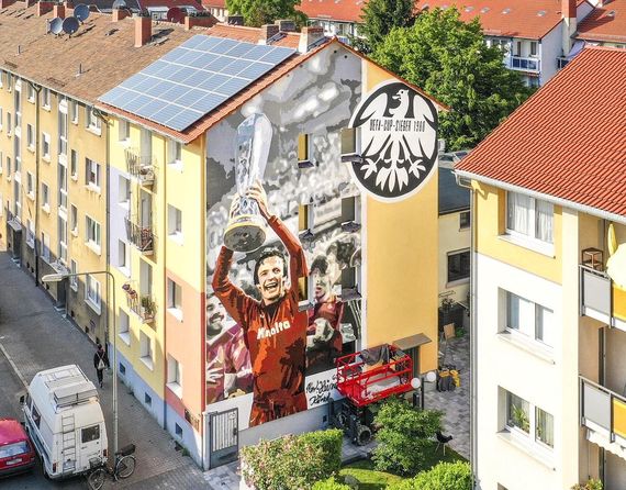 So sieht das fertige Kunstwerk aus.<br />Bild: Eintracht-Online.net”><figcaption>So sieht das fertige Kunstwerk aus.<br />Bild: Eintracht-Online.net</figcaption></figure>
                </div>
                
                <!-- YouTube (Meta-Feld) -->
                
            </div>
        </article>

                <script>
        (function() {
            var root = document.querySelector('.ff-single-news-gallery');
            if (!root) return;
            var slides = root.querySelectorAll('.ff-single-news-gallery-slide');
            var dots = root.querySelectorAll('.ff-single-news-gallery-dot');
            var prev = root.querySelector('.ff-single-news-gallery-prev');
            var next = root.querySelector('.ff-single-news-gallery-next');
            var n = slides.length;
            if (n < 2) return;
            var i = 0;
            function closeAllImgInfo() {
                root.querySelectorAll('.ff-fv-img-info-host.is-info-open').forEach(function(host) {
                    host.classList.remove('is-info-open');
                    var b = host.querySelector('.ff-fv-img-info-btn');
                    var p = host.querySelector('.ff-fv-img-info-panel');
                    if (b) b.setAttribute('aria-expanded', 'false');
                    if (p) p.setAttribute('aria-hidden', 'true');
                });
            }
            function show(idx) {
                closeAllImgInfo();
                i = ((idx % n) + n) % n;
                for (var s = 0; s < n; s++) {
                    if (s === i) slides[s].removeAttribute('hidden'); else slides[s].setAttribute('hidden', '');
                }
                for (var s = 0; s < dots.length; s++) {
                    dots[s].classList.toggle('is-active', s === i);
                    dots[s].setAttribute('aria-selected', s === i ? 'true' : 'false');
                }
            }
            if (prev) prev.addEventListener('click', function() { show(i - 1); });
            if (next) next.addEventListener('click', function() { show(i + 1); });
            for (var d = 0; d < dots.length; d++) {
                (function(di) { dots[di].addEventListener('click', function() { show(di); }); })(d);
            }
        })();
        </script>
        
        <!-- Kommentare -->
                <section class=